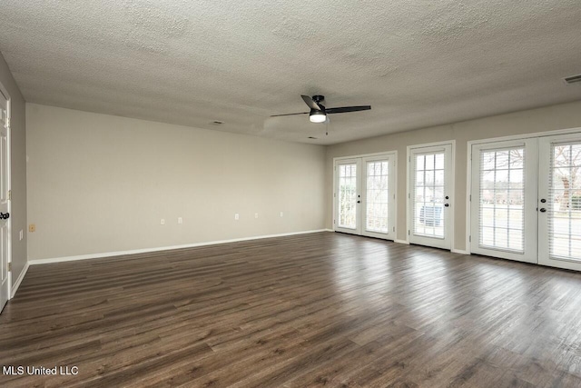 empty room featuring baseboards, dark wood finished floors, a ceiling fan, and french doors