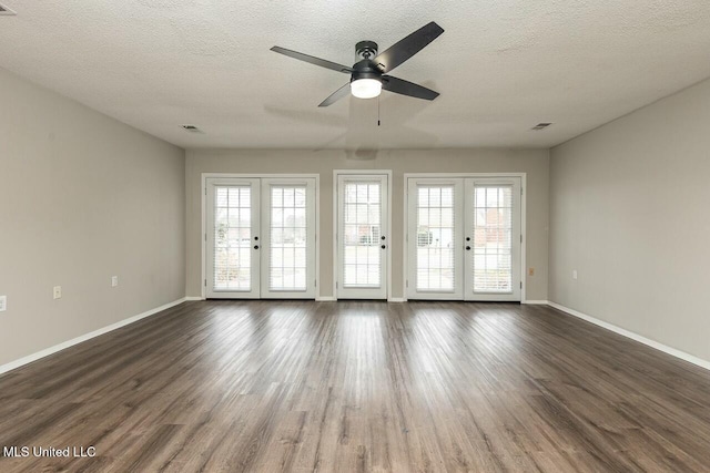 empty room featuring french doors, visible vents, and dark wood finished floors