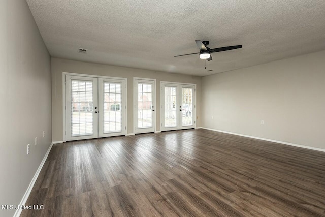 unfurnished room with dark wood-type flooring, french doors, visible vents, and baseboards