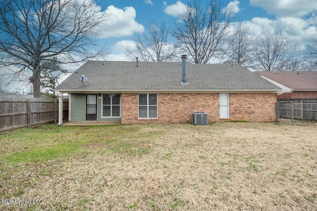 back of house with a fenced backyard, a lawn, brick siding, and roof with shingles