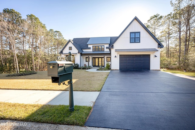 modern farmhouse featuring a front lawn and a garage