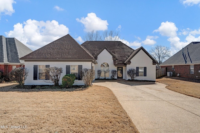 view of front of home featuring a front lawn, roof with shingles, central AC unit, and brick siding