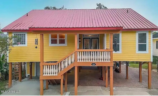 back of house with a carport and covered porch