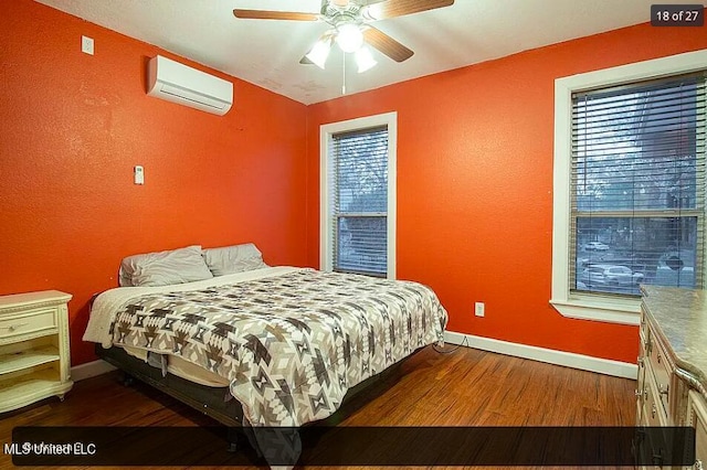 bedroom featuring dark wood-type flooring, ceiling fan, and a wall mounted AC