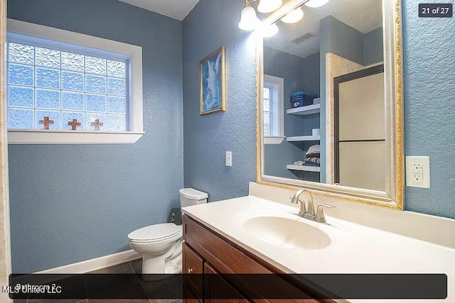 bathroom featuring vanity, toilet, an enclosed shower, and tile patterned flooring