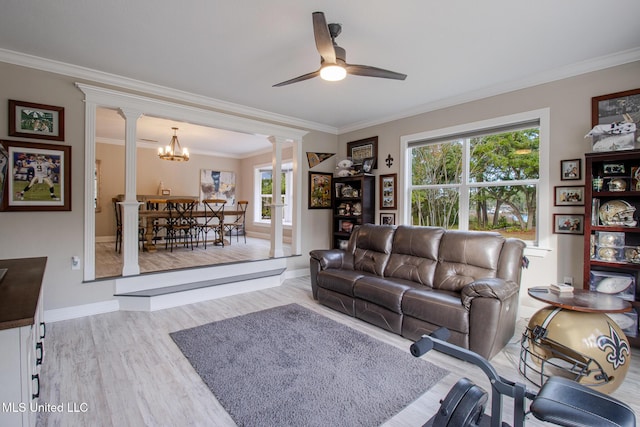 living room featuring ceiling fan with notable chandelier, light hardwood / wood-style floors, ornate columns, and crown molding