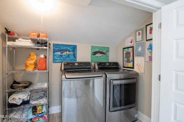 washroom with washing machine and dryer and a textured ceiling