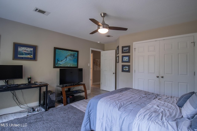 bedroom featuring hardwood / wood-style floors, ceiling fan, and a closet