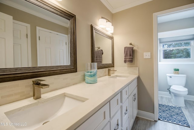 bathroom with decorative backsplash, vanity, crown molding, wood-type flooring, and toilet