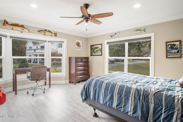 bedroom featuring ceiling fan, crown molding, light hardwood / wood-style flooring, and multiple windows