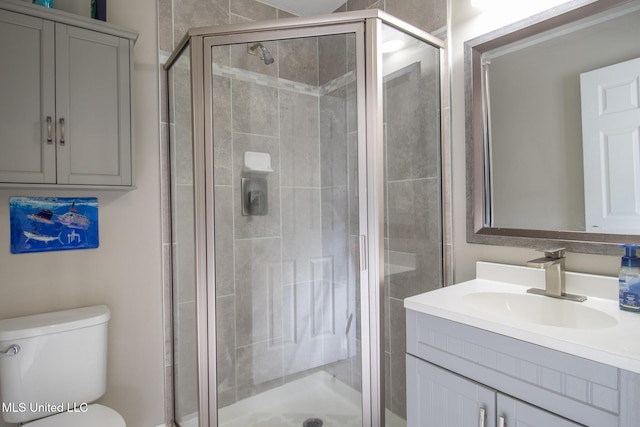 bathroom with vanity, toilet, and a shower with shower door