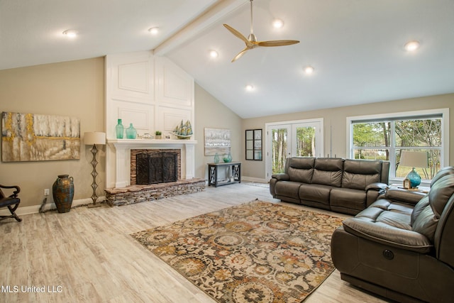 living room featuring high vaulted ceiling, a stone fireplace, ceiling fan, light wood-type flooring, and beam ceiling