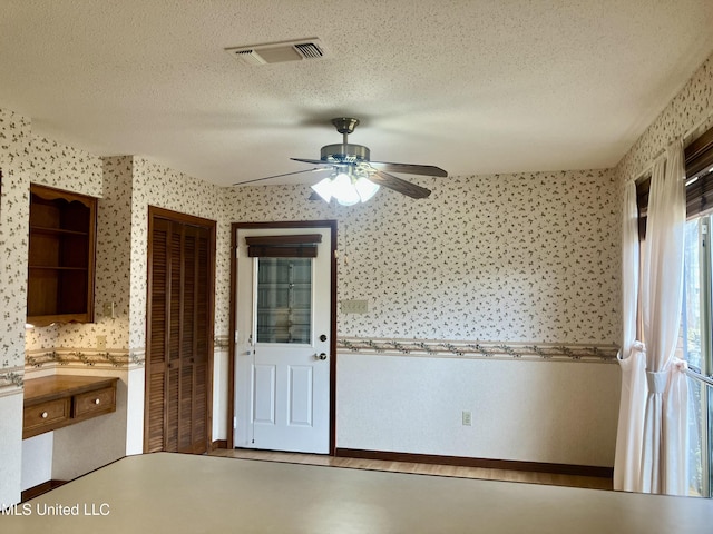 kitchen with ceiling fan and a textured ceiling