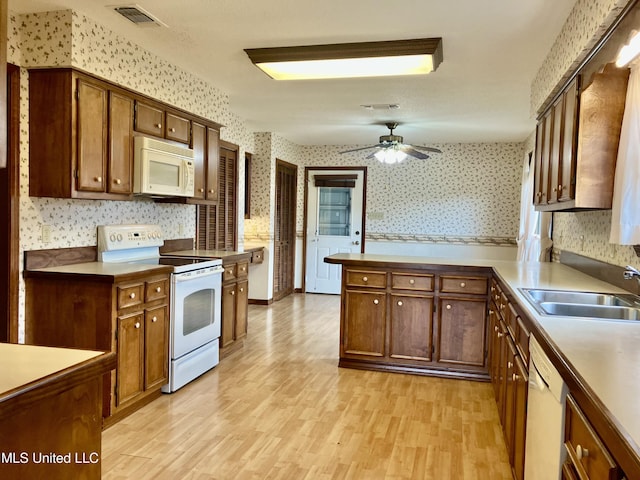 kitchen featuring sink, white appliances, light hardwood / wood-style floors, and ceiling fan