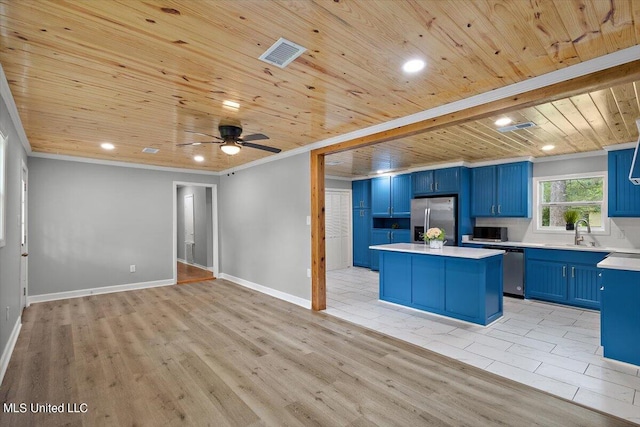 kitchen with light hardwood / wood-style floors, appliances with stainless steel finishes, and blue cabinetry