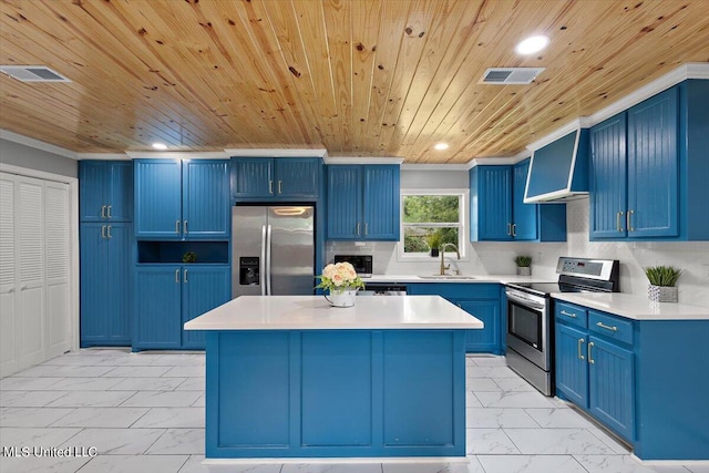 kitchen with blue cabinetry, a center island, stainless steel appliances, and range hood