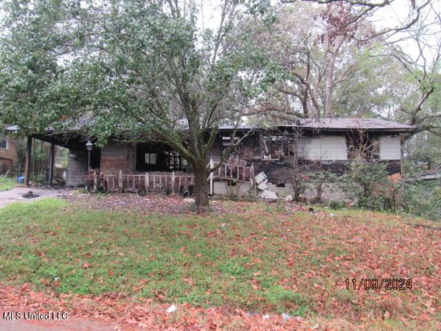 2701 Revere St, Jackson, MS 39212 - view of property hidden behind natural elements featuring a front lawn