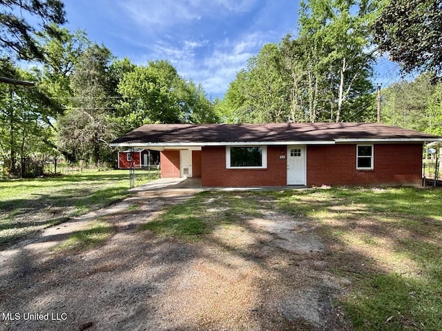 view of front of home featuring a carport, driveway, a front lawn, and brick siding