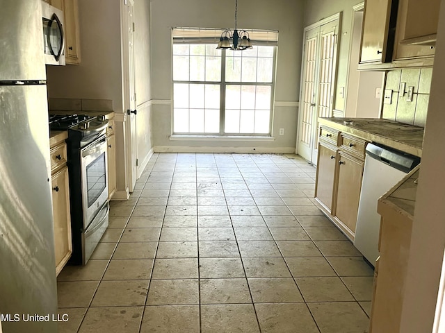 231 Clark Farms Rd, Madison, MS 39110 - kitchen with stainless steel appliances, baseboards, light tile patterned flooring, hanging light fixtures, and a chandelier