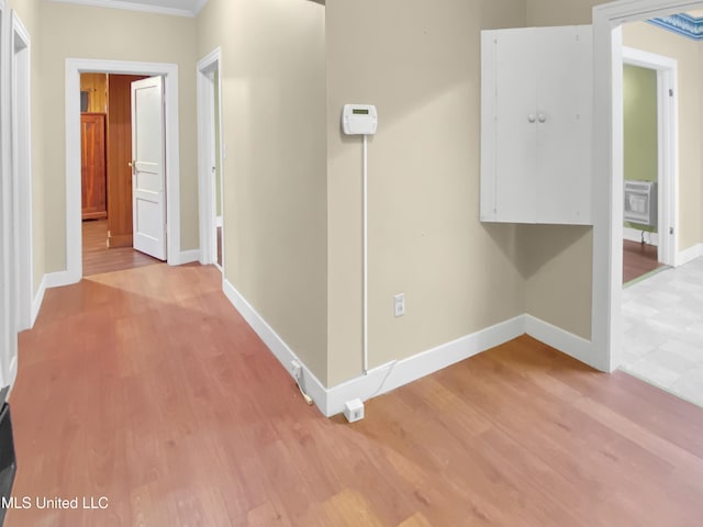 corridor featuring crown molding and light hardwood / wood-style floors