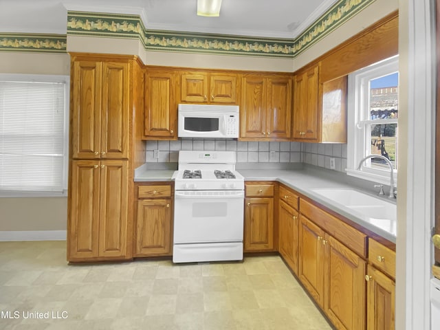 kitchen featuring decorative backsplash, sink, and white appliances