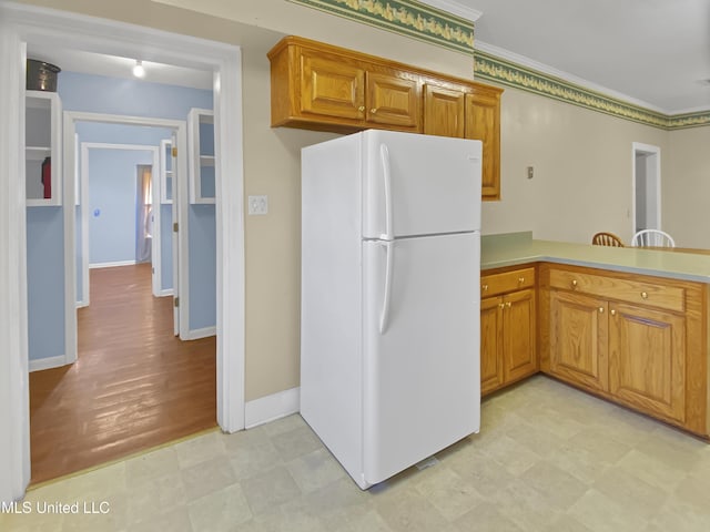 kitchen with white refrigerator and ornamental molding