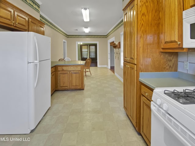 kitchen with crown molding, kitchen peninsula, and white appliances