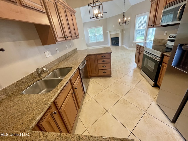 7309 Gerralyn Cv, Olive Branch, MS 38654 - kitchen featuring stainless steel appliances, brown cabinets, a chandelier, light tile patterned floors, and a peninsula