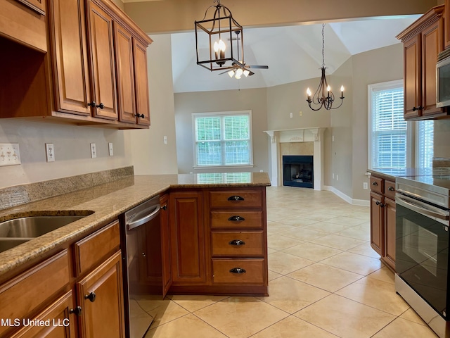 7309 Gerralyn Cv, Olive Branch, MS 38654 - kitchen featuring stainless steel appliances, brown cabinets, a chandelier, lofted ceiling, and a fireplace