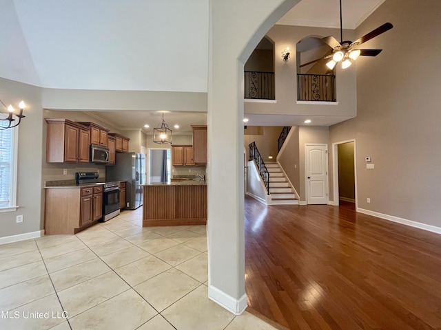 7309 Gerralyn Cv, Olive Branch, MS 38654 - kitchen with appliances with stainless steel finishes, a ceiling fan, brown cabinetry, ornamental molding, and open floor plan