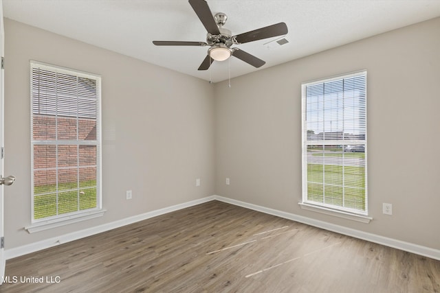 7306 George Ln, Horn Lake, MS 38637 - unfurnished room with wood finished floors, baseboards, plenty of natural light, and a ceiling fan
