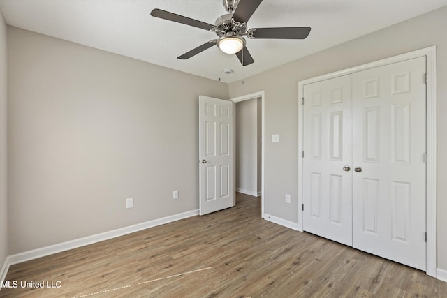 7306 George Ln, Horn Lake, MS 38637 - unfurnished bedroom with light wood-style flooring, baseboards, a closet, and ceiling fan