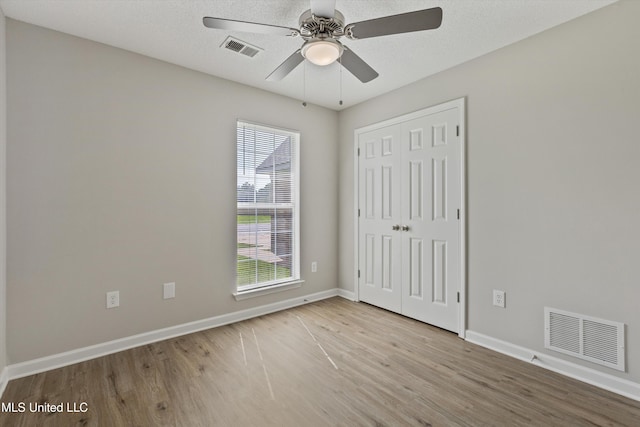 7306 George Ln, Horn Lake, MS 38637 - unfurnished bedroom with wood finished floors, baseboards, a closet, and ceiling fan
