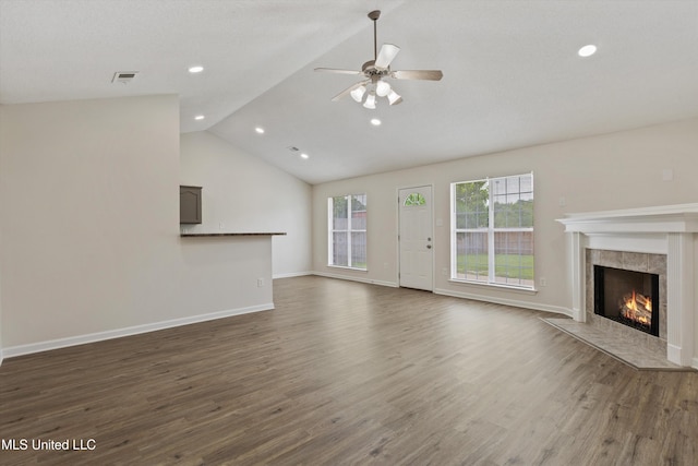 7306 George Ln, Horn Lake, MS 38637 - unfurnished living room featuring a tile fireplace, a ceiling fan, dark wood-style floors, baseboards, and vaulted ceiling
