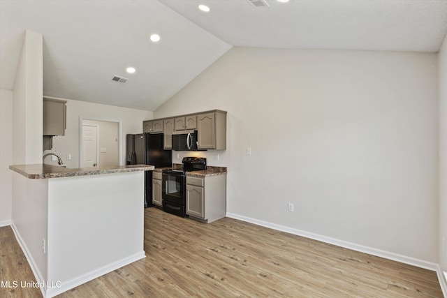 7306 George Ln, Horn Lake, MS 38637 - kitchen with black appliances, gray cabinets, light wood finished floors, lofted ceiling, and baseboards