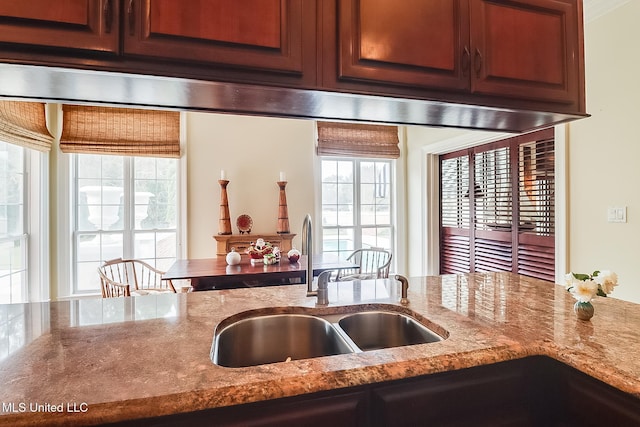 kitchen featuring light stone counters and sink