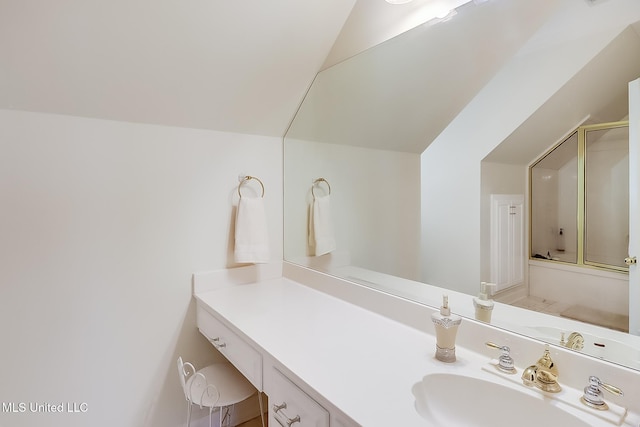 bathroom featuring vanity, vaulted ceiling, and bath / shower combo with glass door