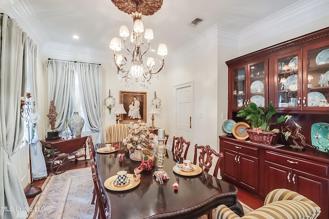 dining space featuring a notable chandelier, wood-type flooring, and crown molding