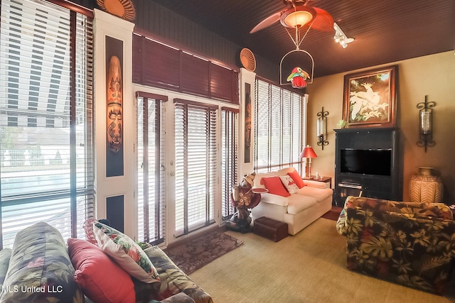 living room with ceiling fan, plenty of natural light, and carpet