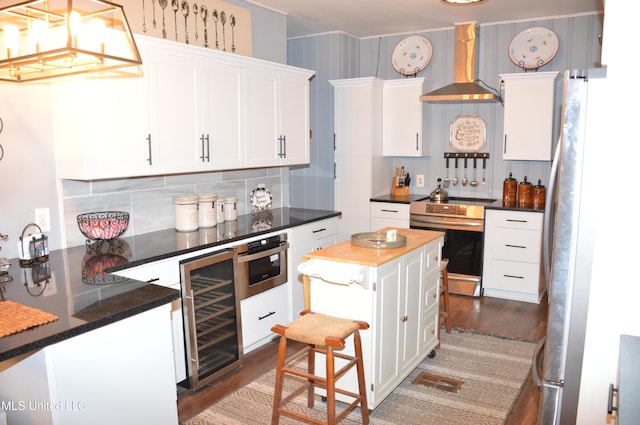 kitchen featuring appliances with stainless steel finishes, dark hardwood / wood-style flooring, beverage cooler, exhaust hood, and white cabinetry