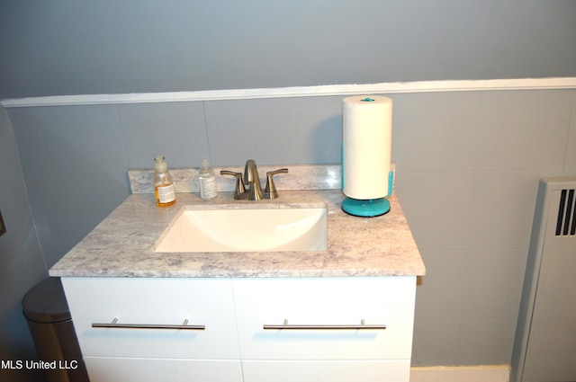 bathroom featuring vanity and tile walls