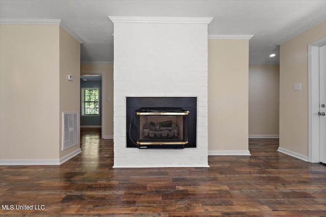 unfurnished living room featuring crown molding, a large fireplace, and dark wood-type flooring