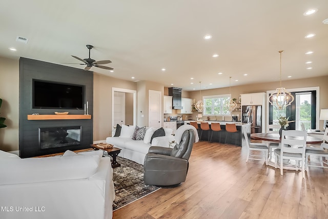 118 Sea Oaks Blvd, Long Beach, MS 39560 - living room with ceiling fan, light wood-type flooring, a chandelier, recessed lighting, and a fireplace