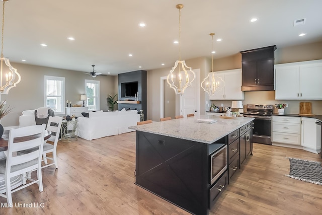 118 Sea Oaks Blvd, Long Beach, MS 39560 - kitchen with a chandelier, stainless steel appliances, white cabinetry, light wood-type flooring, and recessed lighting