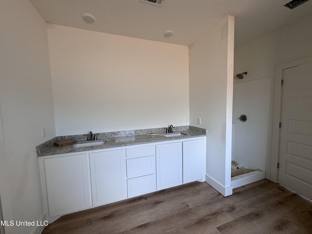 bathroom with vanity, hardwood / wood-style floors, and a shower