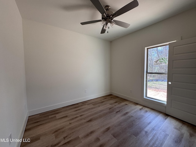 empty room featuring hardwood / wood-style flooring, a wealth of natural light, and ceiling fan