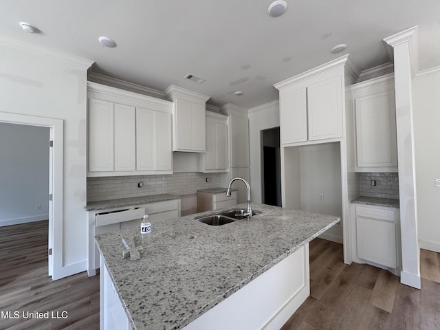 kitchen with white cabinetry, an island with sink, sink, and crown molding