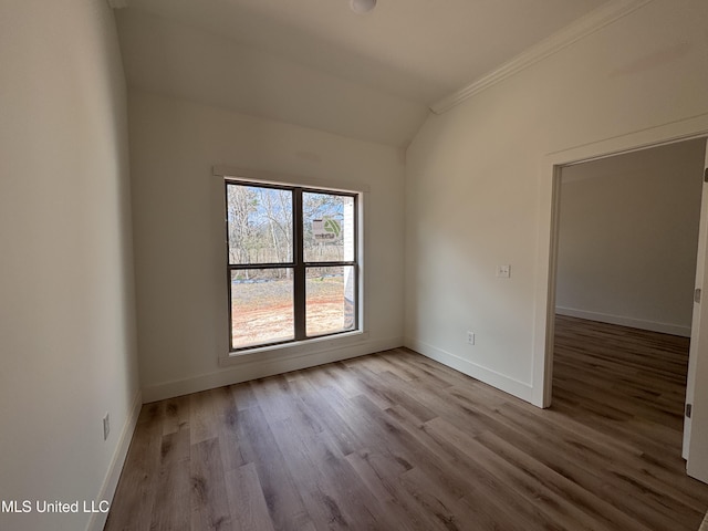 unfurnished room featuring light hardwood / wood-style flooring and vaulted ceiling