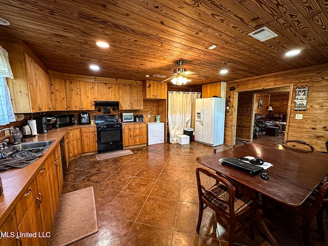 106 Crockrell Rd, Lexington, MS 39095 - kitchen featuring dark tile patterned flooring, black appliances, ceiling fan, wooden ceiling, and wooden walls