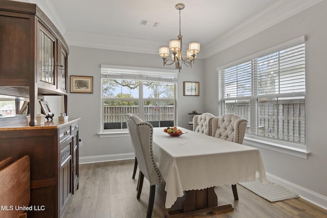 dining room featuring a chandelier, wood finished floors, and ornamental molding